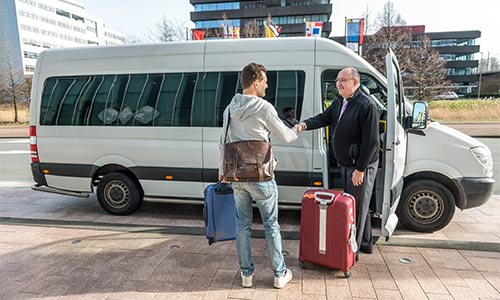 Driver helping a passenger at a van.